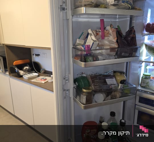 מקרר פתוח עם מדפים מלאים במוצרים שונים